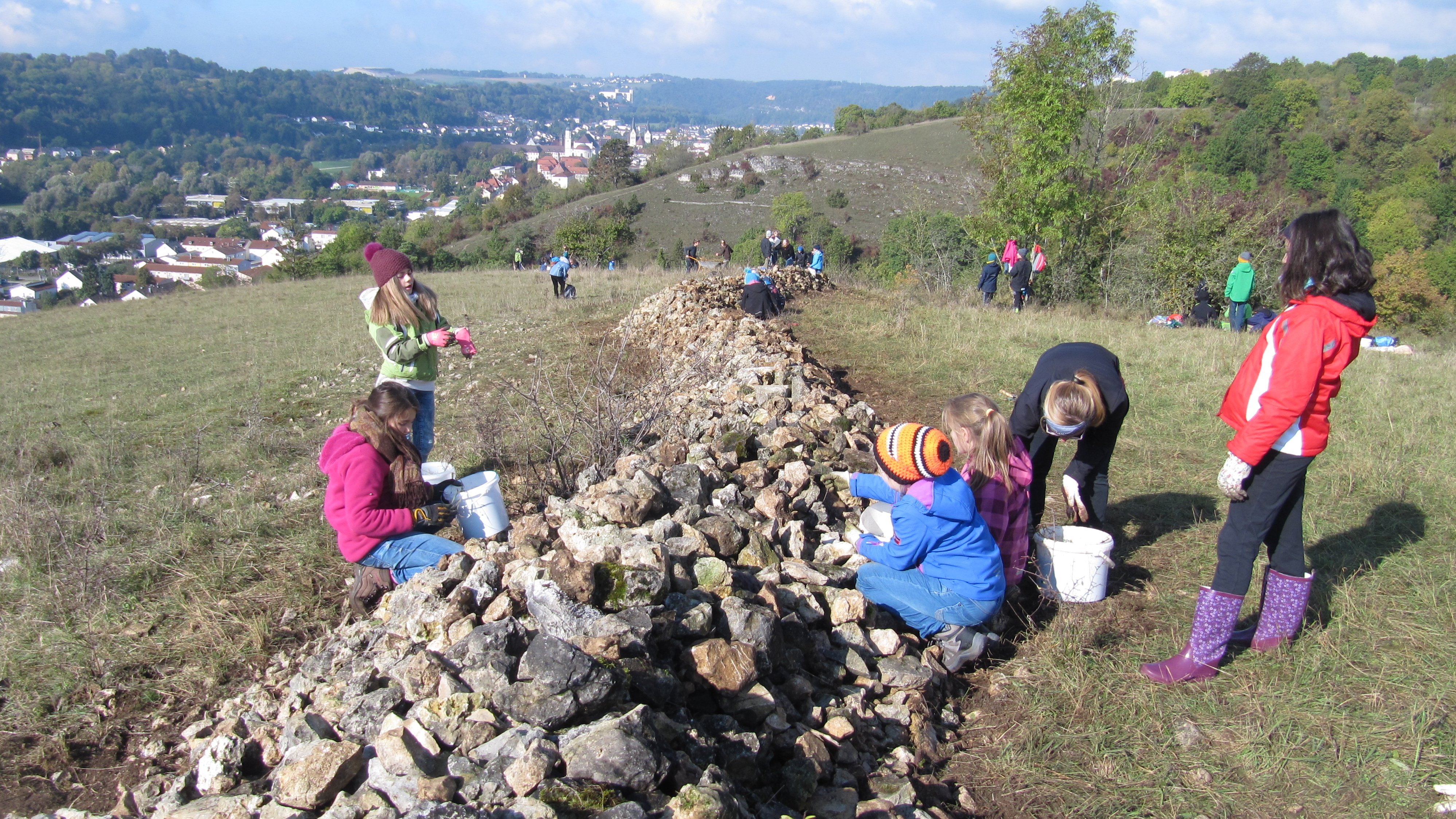 Schulkinder stellen einen Steinriegel frei